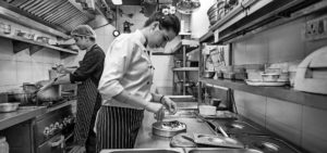 Anahita N. Dhondy working in the kitchen of SodaBottleOpenerWala.